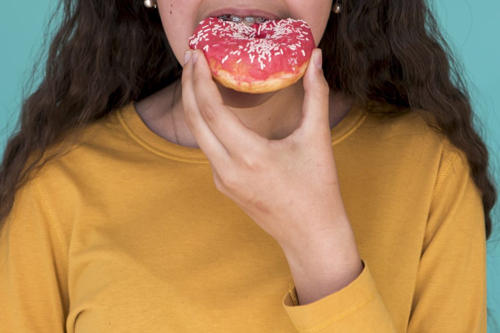 Niña comiendo una dona.