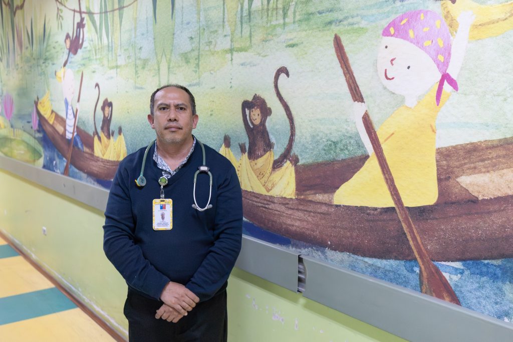 El Dr. Gabriel Cortés posa frente al mural del Servicio de Onco Hematología Pediátrica